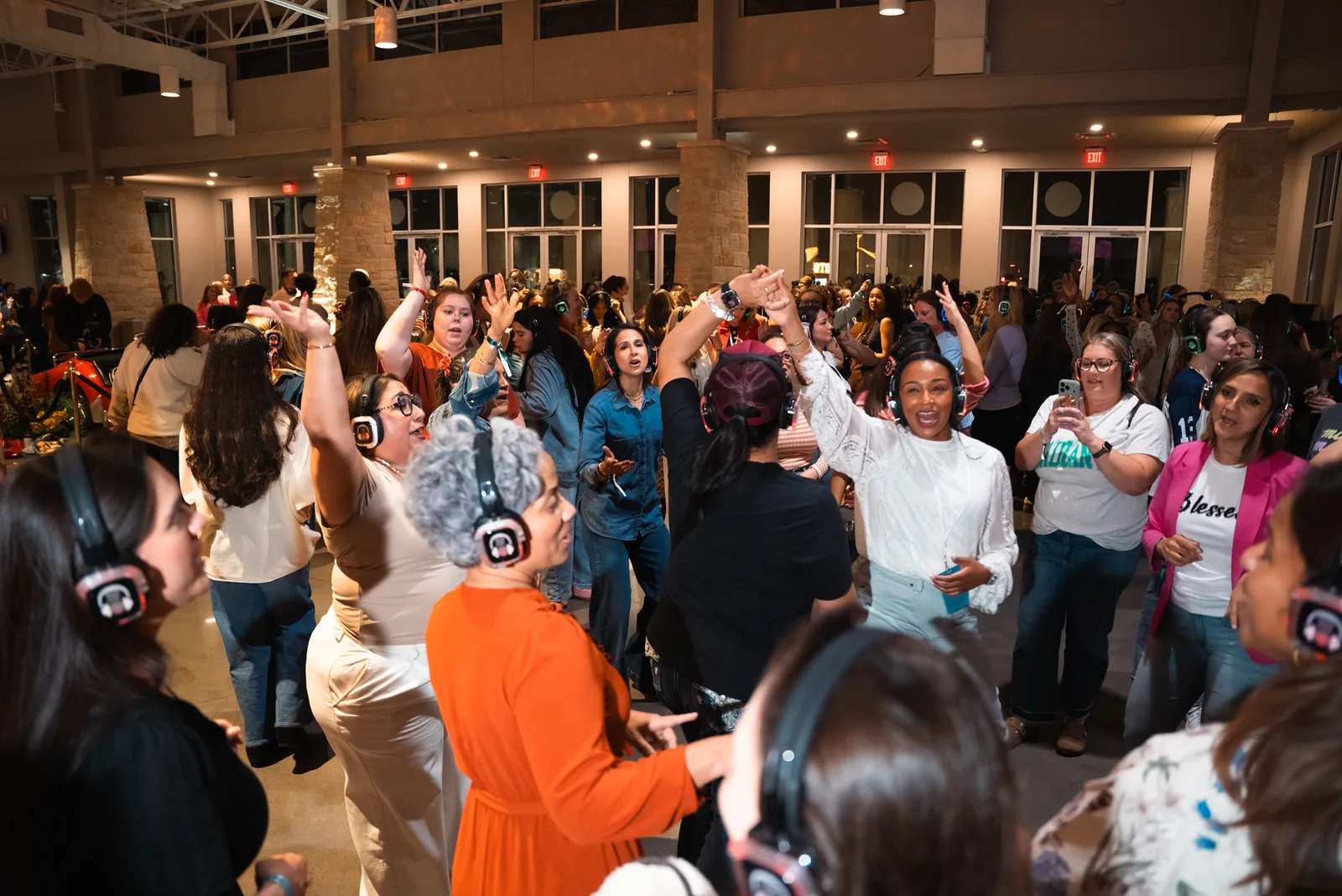 Guests dancing at a women’s church conference, headphones on