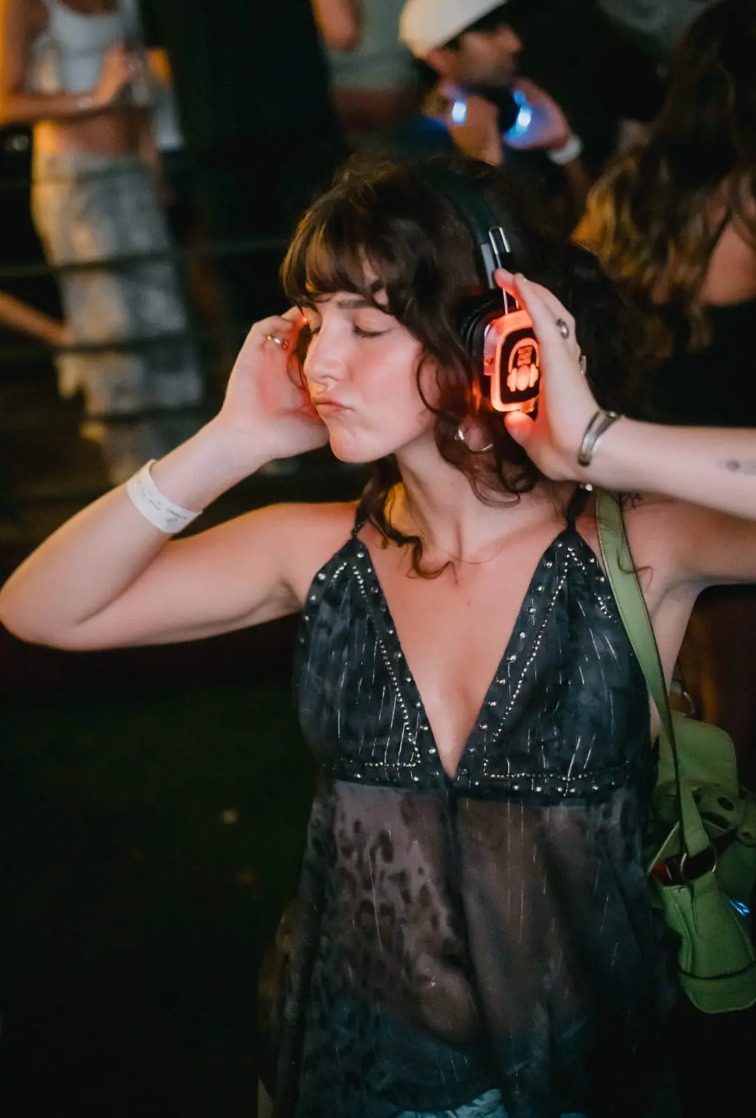 Eyes closed, hands on her headphones — lost in the music