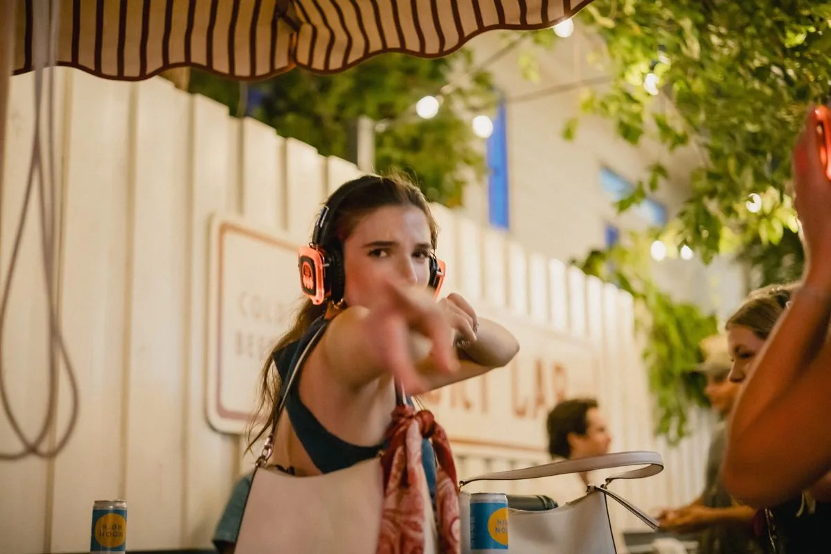 A guest pointing at the camera, headphones glowing