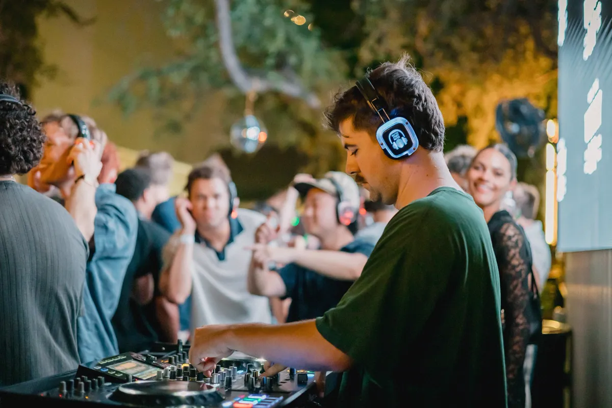 A DJ working the decks with the crowd close behind