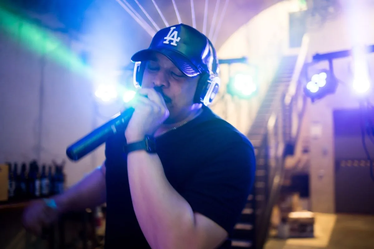 The MC working the room with a mic, headphones on