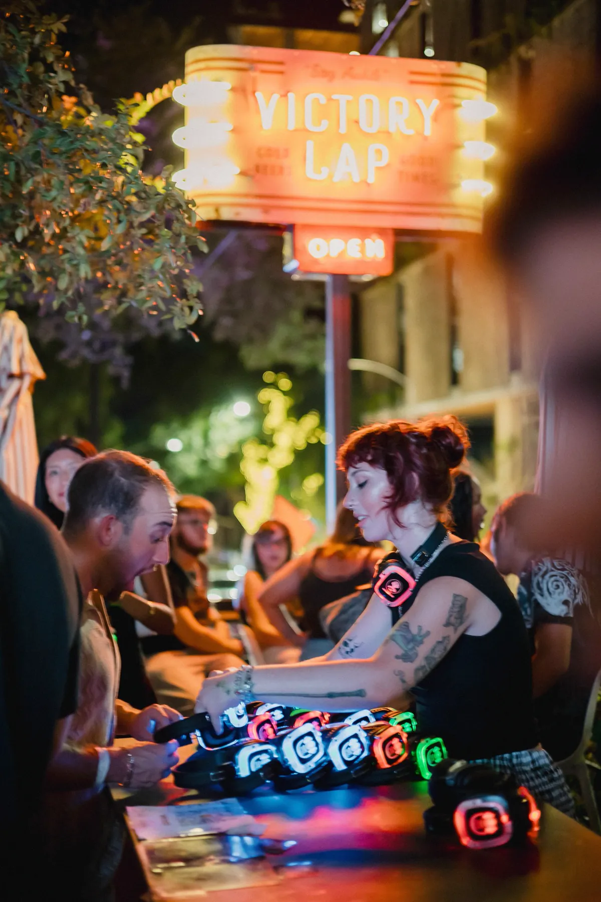 Guests picking up glowing headphones from a table at a DIY setup